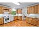 Well-lit kitchen with wooden cabinets, modern appliances, and hardwood floors at 5939 Florasaline Dr, Mebane, NC 27302
