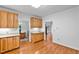 Kitchen area with wood cabinets, hardwood floors, and views into adjacent dining and living areas at 5939 Florasaline Dr, Mebane, NC 27302