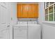 Functional laundry room featuring a washer, dryer, and storage cabinets at 5939 Florasaline Dr, Mebane, NC 27302