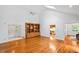 Bright living room with hardwood floors, built-in shelving, and ample natural light from the skylight at 5939 Florasaline Dr, Mebane, NC 27302