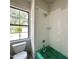 Bathroom featuring a green bathtub with white tiled walls and a window at 6501 Burnette Flower Way, Raleigh, NC 27612