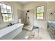 Bright bathroom with soaker tub, walk-in shower with neutral tiling, and windows with lots of light at 6501 Burnette Flower Way, Raleigh, NC 27612