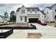 A charming two-story home features an attached garage, a driveway with a red car, and construction fencing at 6501 Burnette Flower Way, Raleigh, NC 27612