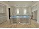 A spacious kitchen features natural wood floors, a large island, white cabinets, and plenty of natural light at 6501 Burnette Flower Way, Raleigh, NC 27612