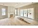 A spacious living room features natural wood floors, a fireplace, large windows, and sliding doors to the patio at 6501 Burnette Flower Way, Raleigh, NC 27612