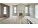 A spacious living room features natural wood floors, a fireplace, large windows, and a door to the patio at 6501 Burnette Flower Way, Raleigh, NC 27612