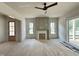 Bright living room with fireplace, wood floors, three windows and adjacent sliding glass doors at 6501 Burnette Flower Way, Raleigh, NC 27612