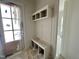 Mudroom featuring built-in storage, bench seating and upper cabinets, with a bright and neutral color palette at 6501 Burnette Flower Way, Raleigh, NC 27612