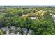 An aerial view of lush greenery with a pond and neighborhood in the distance at 6604 Frogstool Ln, Raleigh, NC 27610