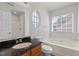 Bathroom including standard tub, shower, sink, and oval decorative window at 6604 Frogstool Ln, Raleigh, NC 27610