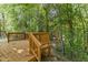 Backyard deck with wooden railings, nestled in a lush, green, wooded environment at 6604 Frogstool Ln, Raleigh, NC 27610
