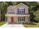 Charming two-story home with red door and shutters and landscaped front yard at 6604 Frogstool Ln, Raleigh, NC 27610