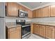 This kitchen features stainless steel appliances, oak cabinets, and granite countertops at 6604 Frogstool Ln, Raleigh, NC 27610