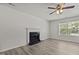 Bright living room featuring a granite fireplace, ceiling fan, and window with lots of natural light at 6604 Frogstool Ln, Raleigh, NC 27610