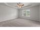 Spacious main bedroom with tray ceiling, ceiling fan, and window overlooking trees at 6604 Frogstool Ln, Raleigh, NC 27610