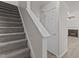 View of the carpeted stairs, white door and hallway with a glimpse into the living room at 6604 Frogstool Ln, Raleigh, NC 27610