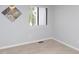 Bright bedroom featuring neutral carpeting, gray walls, and a window offering natural light at 7353 Sandy Creek Dr, Raleigh, NC 27614