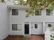 Charming townhome features gray siding, black front door, and brick entryway for a welcoming curb appeal at 7353 Sandy Creek Dr, Raleigh, NC 27614