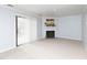 Spacious living room features a cozy fireplace, neutral carpet, and sliding glass door at 7353 Sandy Creek Dr, Raleigh, NC 27614