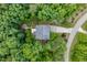 Aerial view of a private wooded lot showcasing a house with a backyard seating area, offering serene outdoor living at 776 Legend Oaks Dr, Chapel Hill, NC 27517