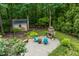 Backyard patio with stone fire pit, outdoor furniture, and a storage shed surrounded by mature trees at 776 Legend Oaks Dr, Chapel Hill, NC 27517