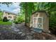 View of a storage shed in the backyard, near a stone path leading towards the house at 776 Legend Oaks Dr, Chapel Hill, NC 27517