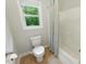 Bright bathroom showcases a toilet, tub with shower, and a window with a nature view at 776 Legend Oaks Dr, Chapel Hill, NC 27517