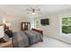 Inviting bedroom features a comfortable bed, flat screen TV, and two windows with views of lush greenery at 776 Legend Oaks Dr, Chapel Hill, NC 27517