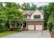 Charming two-story home features a brick facade, two-car garage, and a cozy front porch surrounded by lush landscaping at 776 Legend Oaks Dr, Chapel Hill, NC 27517