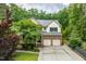 Beautiful two-story brick home with a manicured lawn, two-car garage, and charming front porch in a wooded setting at 776 Legend Oaks Dr, Chapel Hill, NC 27517