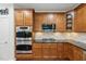 Featuring wood cabinets, stainless steel appliances, granite countertops, tile backsplash, and hardwood floors at 776 Legend Oaks Dr, Chapel Hill, NC 27517