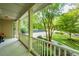 Relaxing front porch with white railing, offering a serene view of the landscaped yard and driveway at 776 Legend Oaks Dr, Chapel Hill, NC 27517