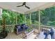 Relaxing screened-in porch features comfortable seating, a ceiling fan, and string lights overlooking a lush, green yard at 776 Legend Oaks Dr, Chapel Hill, NC 27517