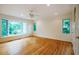 Expansive bedroom featuring hardwood floors, ceiling fan, and large windows providing ample natural light and backyard views at 803 Churchill Dr, Chapel Hill, NC 27517
