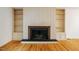 Close up of a beautiful fireplace with white built-in shelving on either side and hardwood floors at 803 Churchill Dr, Chapel Hill, NC 27517