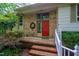 Inviting front entrance with a red door, brick steps, and a decorative wreath accenting the brick facade at 803 Churchill Dr, Chapel Hill, NC 27517