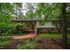 Charming brick home with a well-manicured lawn, mature trees, and a welcoming red front door at 803 Churchill Dr, Chapel Hill, NC 27517