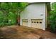 Attached two-car garage with adjacent driveway, surrounded by lush landscaping at 803 Churchill Dr, Chapel Hill, NC 27517