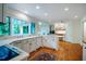 Well-lit kitchen featuring white cabinetry, hardwood floors, and a large window offering a scenic view at 803 Churchill Dr, Chapel Hill, NC 27517