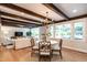 Bright dining area with exposed beams, chandelier, and seamless flow to the living room at 813 Faulkner Pl, Raleigh, NC 27609