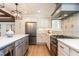 Well-lit kitchen with stainless steel refrigerator, light-colored cabinets, and a stove beneath an ornate vent at 813 Faulkner Pl, Raleigh, NC 27609