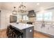 Stunning kitchen with white cabinetry, stainless steel appliances, island with barstool seating, and stylish backsplash at 813 Faulkner Pl, Raleigh, NC 27609