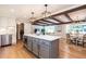 Open kitchen with island featuring a built-in microwave, wood floors, and seamless flow to dining and living areas at 813 Faulkner Pl, Raleigh, NC 27609