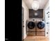 Convenient laundry area equipped with modern washer and dryer, storage cabinets, and stylish overhead lighting at 813 Faulkner Pl, Raleigh, NC 27609