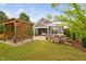 A backyard featuring a wood pergola, stone outdoor kitchen and covered patio at 829 Churton Pl, Cary, NC 27518