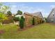 A sprawling backyard featuring a wood trellis, outdoor kitchen and green grass at 829 Churton Pl, Cary, NC 27518