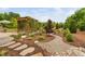 Beautiful backyard with stone walkway, mulch, and wooden pergola covered in climbing vines and surrounding greenery at 829 Churton Pl, Cary, NC 27518
