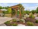 Scenic backyard with a stone patio, a vine covered pergola, and artful landscaping with mature trees and a bird bath at 829 Churton Pl, Cary, NC 27518