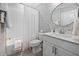 Bright bathroom featuring a tub/shower combo and vanity with blue patterned wallpaper at 829 Churton Pl, Cary, NC 27518