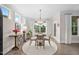 Bright dining area with a round table, stylish chairs, and a view of the outdoor greenery through large windows at 829 Churton Pl, Cary, NC 27518